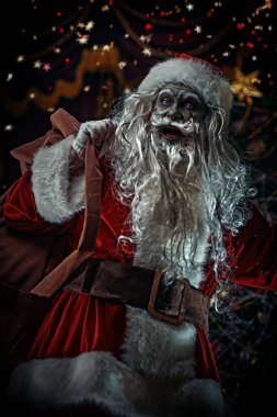 Noel ve Cadılar Bayramı. Korkunç Zombi Noel Baba arkasında hediyelerle dolu bir çantayla Noel süslemesiyle örümcek ağlarına dolanmış ve şeytanca gülümsüyor..