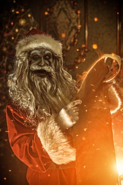 Noel ve Cadılar Bayramı. Korkunç Zombi Noel Baba, kara listesiyle Noel süslemeli bir odada duruyor. Örümcek ağlarına dolanmış ve şeytanca gülümsüyor..