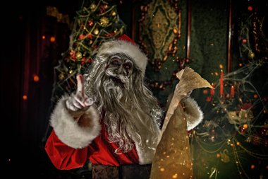 Noel ve Cadılar Bayramı. Korkunç Zombi Noel Baba, kara listesiyle Noel süslemeli bir odada duruyor. Örümcek ağlarına dolanmış ve şeytanca gülümsüyor..