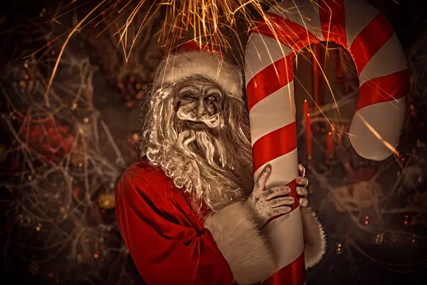 Korkunç zombi Noel Baba Noel süslemesi ve örümcek ağıyla çevrili ve şeytanca gülümseyen bir odada Noel şekeri kamışını tutuyor. Noel 'de kabus. Cadılar Bayramı