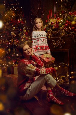 Neşeli, güzel anne ve sevgili kızı Noel arifesini sıcak bir aile ortamında şömine ve kostüm ağacının yanında oturarak geçiriyorlar. Mutlu Noeller aile.. 