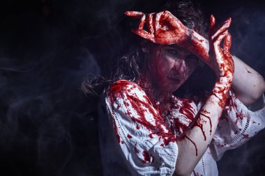 Karanlık bir odada zayıf bir şekilde duran kana bulanmış zavallı masum bir kızın ürkütücü portresi. Korku, gerilim. Cadılar Bayramı. Vampirler. Boşluğu kopyala.