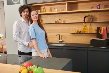 Genç ve güzel bir çift evdeki mutfakta mutlu saatler geçiriyorlar. Evde aile hayatı. Modern iç mekan, mobilya.