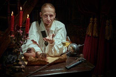 Orta Çağ 'ın sonlarına doğru bir asilzade elinde tüfeği ve masada bir rapier ile bir şatoda otururken bir mektup yazar. Tarihi yeniden yapılandırma. Fantezi kahramanı.