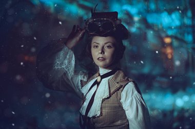 Macera romanı, steampunk bilim kurgu. 19. yüzyıl takım elbiseli zarif bir bayanın portresi ve tren istasyonunda poz veren bir şapka. Steampunk 'lı kadın. Tarihi moda ve saç stili. 