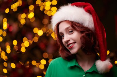 Mutlu Noeller ve mutlu yıllar! Mutlu, güzel bir kız Noel ağacının yanında gülümsüyor. Sıcak bir Noel evinin büyülü atmosferinde..