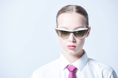 Beyaz gömlekli, kırmızı kravatlı, şık güneş gözlüklü, beyaz stüdyo arka planında güzel bir genç kadının moda fotoğrafı. Başarılı insanlarız. Zarif bir iş tarzı. Boşluğu kopyala.