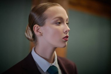 Kendine güvenen güzel bir kadının portresi şık bir takım elbise, beyaz gömlek ve lüks bir iç mekan kravatı içinde poz veriyor. Moda. Lüks bir iş tarzı. İş kıyafetleri tarzı.