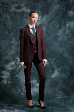 Zarif kahverengi takım elbiseli, kravatlı ve beyaz gömlekli muhteşem bir genç kadının tam boy portresi. Karanlık stüdyo geçmişi. Başarılı insanlarız. Zarif bir iş tarzı. Moda fotoğrafı..