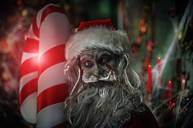 Korkunç zombi Noel Baba Noel süslemesi ve örümcek ağıyla çevrili ve şeytanca gülümseyen bir odada Noel şekeri kamışını tutuyor. Noel 'de kabus. Cadılar Bayramı