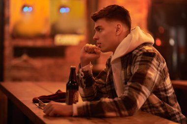 Modern bir genç adam bir barda bira içerek zaman geçirir. Boş zaman, yaşam tarzı..
