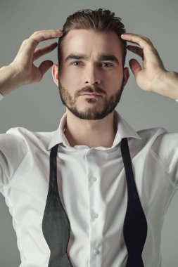 Klasik şık giyimli yakışıklı bir adamın portresi. Erkek güzelliği ve moda. Gri arkaplanda stüdyo portresi.