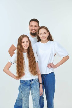 Mutlu, gülümseyen bir babanın iki sevgili kızıyla portresi. Mutlu aile kavramı. Beyaz arkaplanda stüdyo portresi.