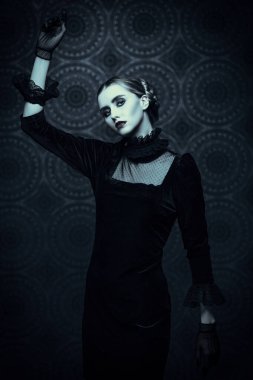Gotik roman, mistisizm. Zarif, siyah kadife elbiseli, ürkütücü, dramatik esmer bir kız gecenin karanlığında eskimiş bir arka planda duruyor. Korku, korku. Cadı portresi. 