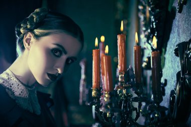 Gotik roman. Katı siyah elbiseli, beyaz yakalı, kasvetli esmer bir kız, geceleri kasvetli bir malikanede mumların yanında tehditkar bir duruş sergiliyor. Addams Ailesi.