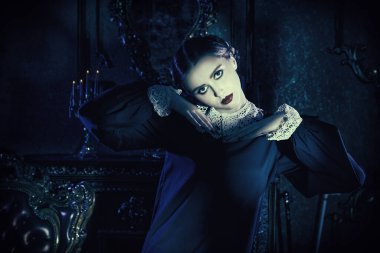 Addams Ailesi tarzı. Kasvetli bir kalede ay ışığında dans eden, katı siyah elbiseli, beyaz yakalı çekici bir esmer kızın portresi. Mistik gotik roman. 