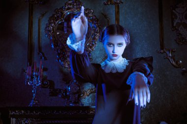 Mistik gotik roman. Kasvetli bir kalede ay ışığında dans eden, katı siyah elbiseli, beyaz yakalı çekici bir esmer kızın portresi. Addams Aile Stili.