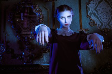 Katı siyah elbiseli, beyaz yakalı, kasvetli bir kalede ay ışığında dans eden çekici bir esmer kız. Addams Ailesi tarzı. Mistik gotik roman. 