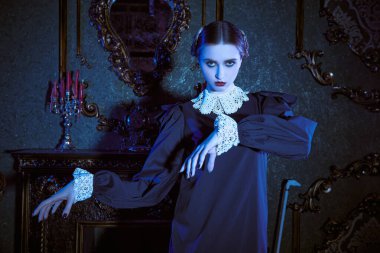 Kasvetli bir şatoda ay ışığında dans eden, katı siyah elbiseli, beyaz yakalı çekici bir esmer kız. Addams Ailesi tarzı. Mistik gotik roman. 