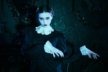 Kasvetli bir kalede ay ışığında dans eden, katı siyah elbiseli, beyaz yakalı çekici bir esmer kızın portresi. Addams Ailesi tarzı. Mistik gotik roman. 