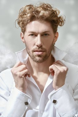 Aşk Tanrısı Aşk Tanrısı. Beyaz elbiseli, beyaz kanatlı ve kameraya sakince bakan yakışıklı bir aşk meleği. Arka planda tavan penceresi var. Sevgililer Günü.