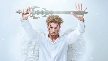 Görkemli Başmelek, önünde bir kılıçla nöbet tutuyor. Beyaz arka plan. Fantezi kahramanı. Sevgililer Günü.