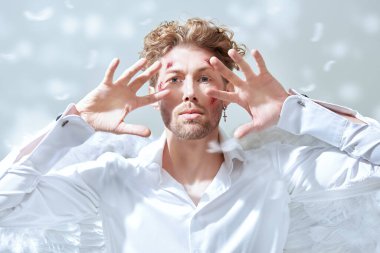 Fantezi kahramanı aşığı. Beyaz elbiseli, beyaz kanatlı, yüzünde yaraları olan çekici bir aşk meleği kameraya bakıyor. Aşk Tanrısı Aşk Tanrısı. Sevgililer Günü.