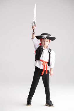 Korsan kostümü giymiş şirin bir çocuğun tam boy fotoğrafı. Çocuklar için kostümlü bir parti. Beyaz stüdyo geçmişi.