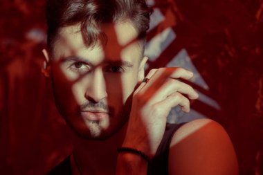 Cesur ve kendinden emin bir şekilde geleceğe bakan yakışıklı bir esmer adamın sanat portresi. Karışık ışıklandırma, ışık ve gölgeler.