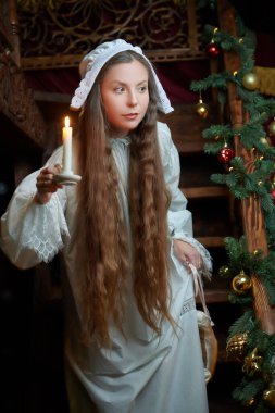 Eski tarz. Gecelik ve kepli güzel aristokrat bayan geceleri bir mum ile zengin bir iç mekanda duruyor. 19. yüzyıl - 20. yüzyıl başlarındaki romanın kahramanı..