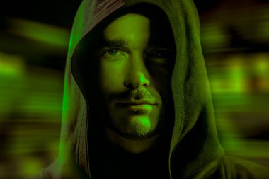 Siyah cüppeli, kafasında başlığı olan cesur bakışlı vahşi bir adam bir gece şehrinin ışıklarında duruyor. Fantezi kahramanı. Uzay ve gelecek dünya hakkında bilim kurgu. Sanal tema.