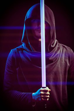 Uzay fantezisi. Bilim kurgu romanı. Siyah cüppeli, kapüşonlu cesur bir savaşçı karanlık bir arka planda lazer kılıcı tutuyor..