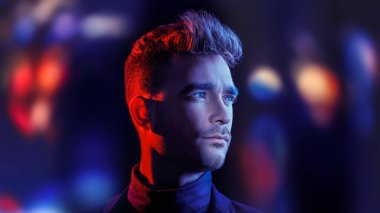 Yan tarafa bakan yakışıklı, vahşi bir adamın portresi. Karma ışık ve kopyalama alanı olan siyah bir stüdyo. Psikolojik sanat portresi.