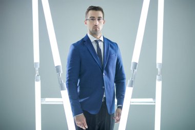 Gözlüklü, meşgul ve başarılı bir iş adamı. Mavi arka plan ve neon lambaları. İş konsepti. 