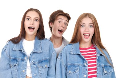 Beyaz stüdyo arka planında poz veren modaya uygun giyinmiş üç neşeli genç. Denim tarzı, gençlik tarzı. Eğitim, duygular.