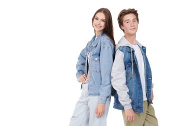Moda giysileri içinde beyaz arka planda fotokopi ile poz veren mutlu genç erkek ve genç kız portresi. Denim tarzı, gençlik tarzı..