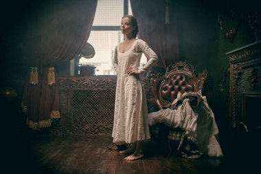 18. yüzyılın İskoç giysileri. Ortaçağ asilzadesi bir kadın 18. yüzyılın klasik iç mimarisi olan bir odada İskoç kostümü ve ayakkabısı giyiyor.. 