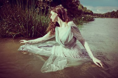 Fabulous myths and legends. A bewitching water nymph is splashing in the water of the river. Fantasy. clipart