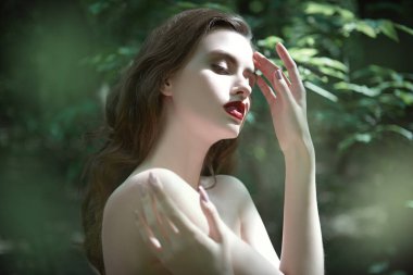 Orman perisi, Dryad. Dalgalı siyah saçlı narin, çıplak bir kız sık bir ormanda ağaçların arasında duruyor. Peri masalı kahramanı, fantezi.