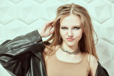 Koyu renkli dumanlı gözlü, uzun taraklı saçlı. Beyaz stüdyo arka planında poz veren çekici rock yıldızı genç kız. Modern gençlik pop ve rock kültürü.