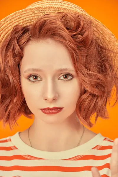 Ruh hali. Parlak kıvırcık saçlı üzgün bir kız kameraya bakıyor. Turuncu stüdyo geçmişi. Hayat resimleri.