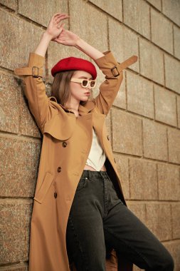 Modada zarif bir retro tarzı var. Uzun dalgalı saçlı güzel bir kadının portresi. Şehir sokaklarında trençkotlu, kırmızı bereli ve bej gözlükle poz veriyor.. 