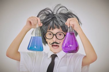 Akıllı bir çocuk laboratuarda mataralarla deney yapıyor. Beyaz arka plan. Eğitici bir kavram. Genç kimyager..