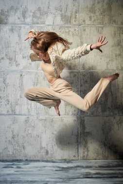 Çağdaş danslar. Grunge stüdyosunda poz veren genç ve güzel bir dansçı..