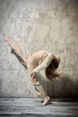 Çağdaş danslar. Grunge stüdyosunda poz veren genç ve güzel bir dansçı..