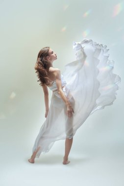 Modern balerin. Narin beyaz elbiseli zarif bir balerin ifade ile dans eder. Tam boy stüdyo resmi..