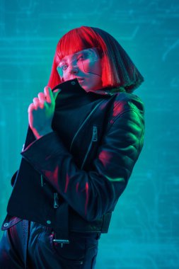 Geleceğin dijital teknolojileri. Fütürist gözlüklü, neon renkli ışıkta duran mükemmel siber kız. Siber uzay. Sanal gerçeklik oyunları.