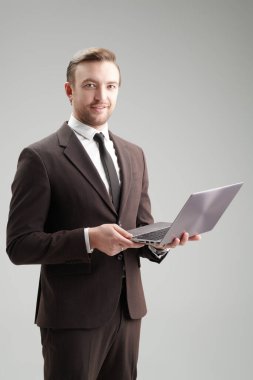 Klasik takım elbiseli ve dizüstü bilgisayarlı orta yaşlı bir iş adamının portresi. Başarılı insanlarız. İş stili. Gri arkaplanda stüdyo portresi.