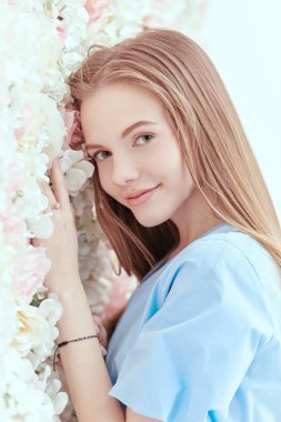 Güzellik ve bahar havası. Hoş bir genç kız, uzun sarı düz saçlı narin çiçekli bir geçmişi var..