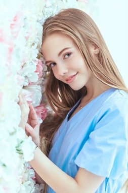 Güzellik ve bahar havası. Hoş bir genç kız, uzun sarı düz saçlı narin çiçekli bir geçmişi var..